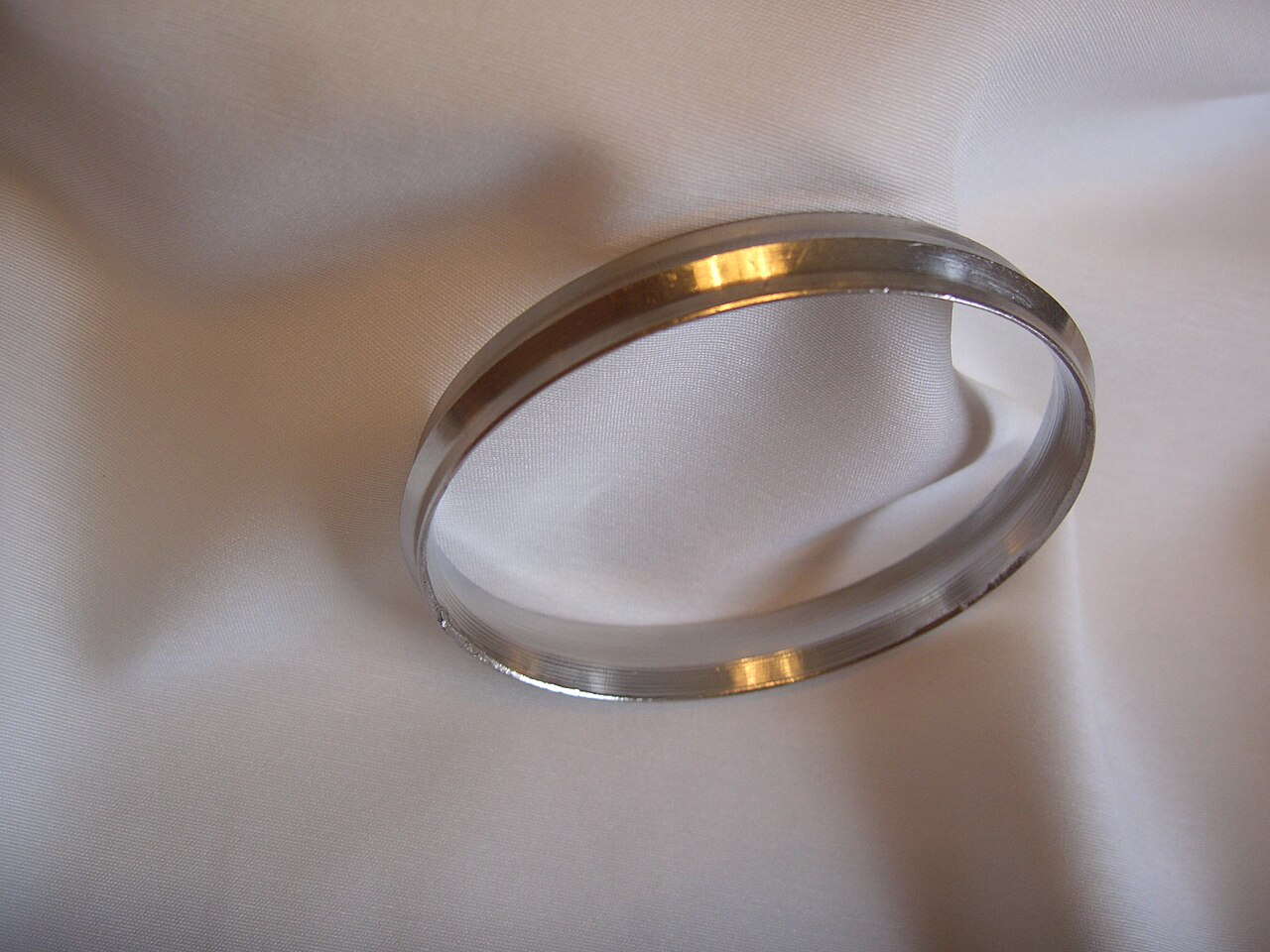 A stainless-steel Kara on white cloth